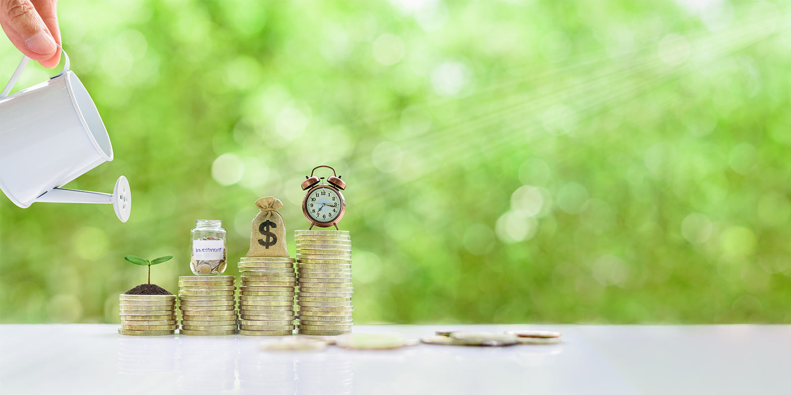 stacked coins with a watering can watering the investments