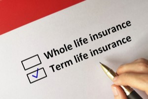 Whole life insurance term life insurance written on paper while hand ticking later option