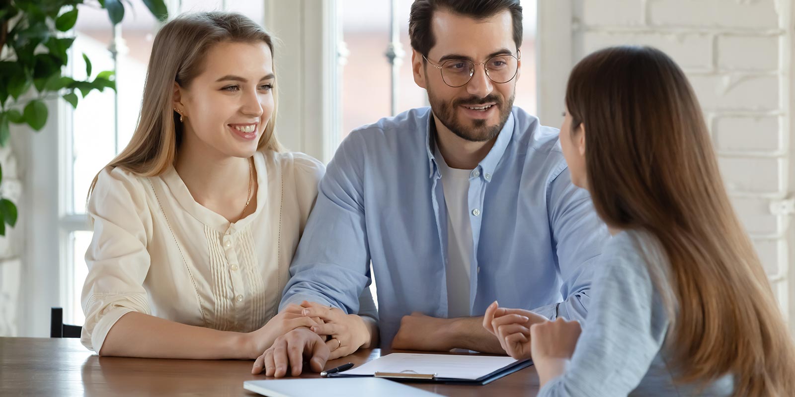 happy young couple speaking with life insurance agent