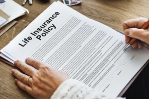 man signing life insurance policy