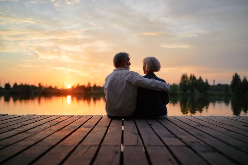 Couple On A Dock Enjoying The Sunset After Looking Over Their Annuity Rollover Options