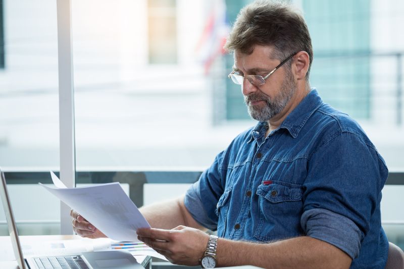 Man Reviewing Documents Related To His Indexed Universal Life Insurance Policy