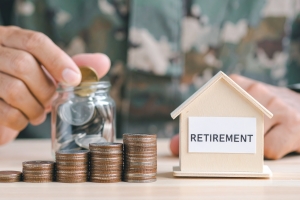 Person Putting Coin in Glass Jar Investing for Retirement