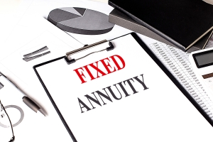 Clipboard with Text Fixed Annuity on A Desk with Financial Charts