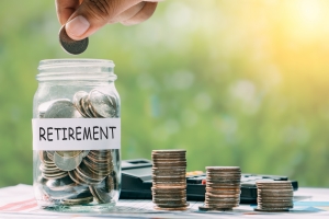 Hand Putting Money in Jar for Retirement Income